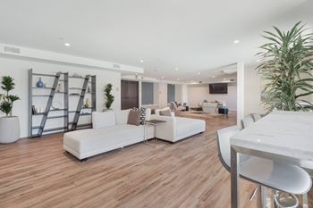 A white sofa set is placed in a room with wooden flooring.